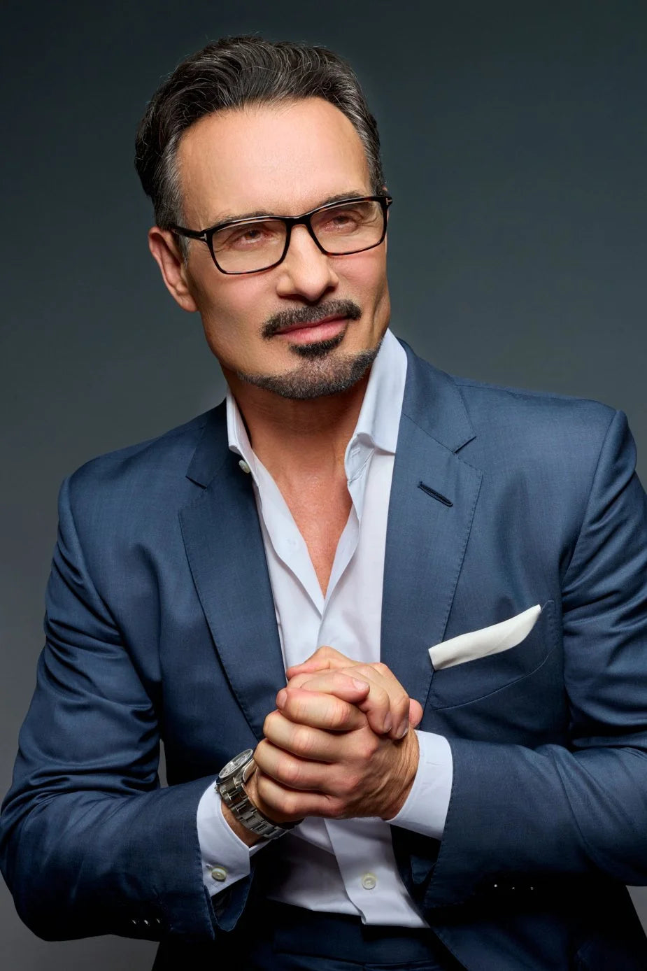 Executive headshot of Daniel Farrar, CEO, in a navy suit and glasses