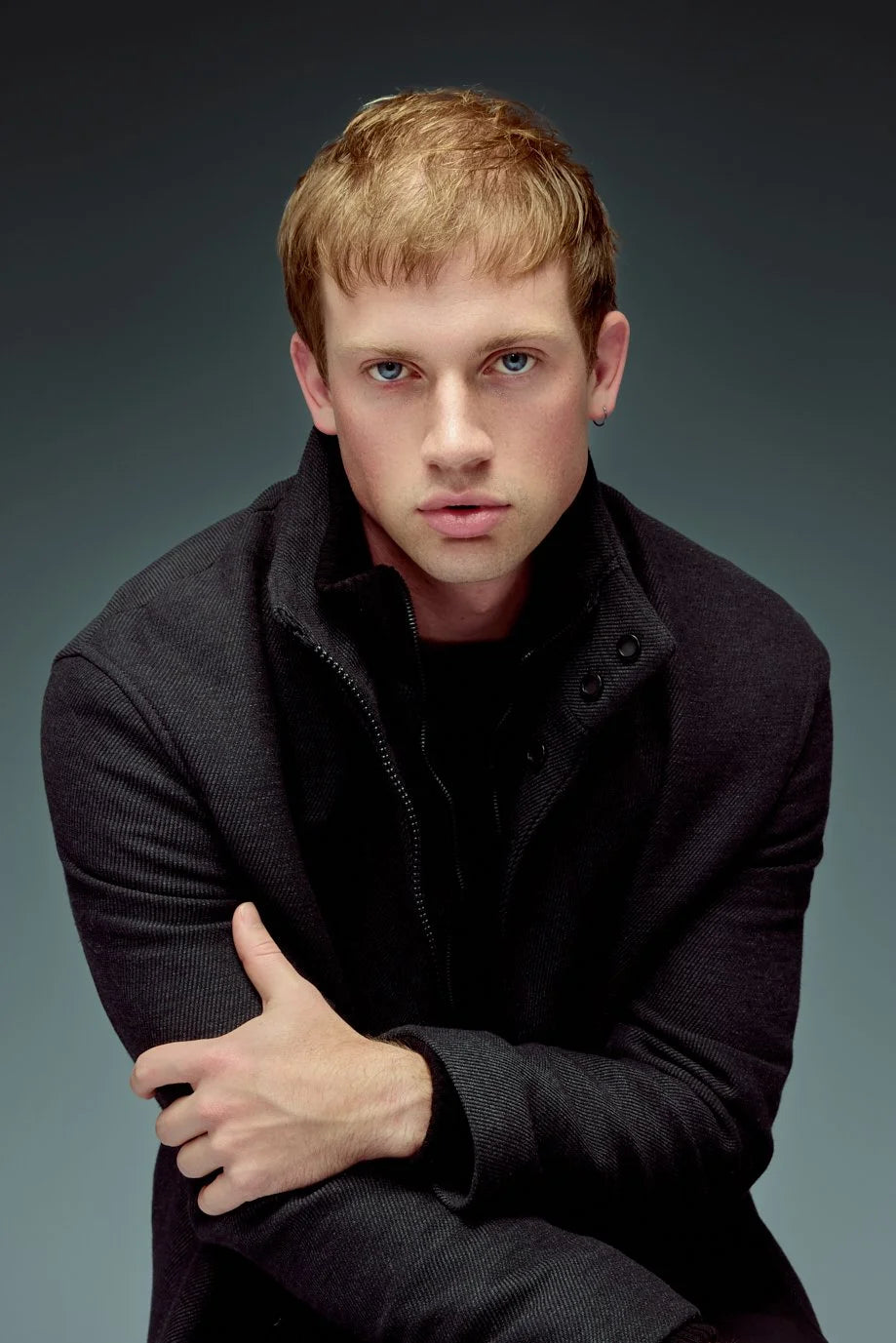 Young man in black, direct expression, studio portrait