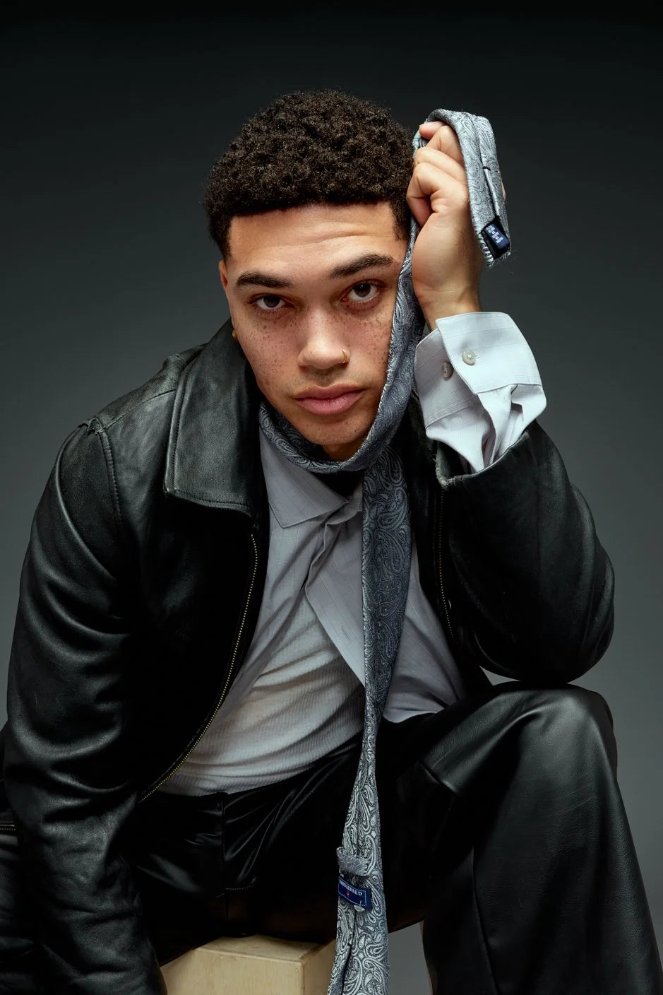 Man in a leather jacket against a cool grey backdrop