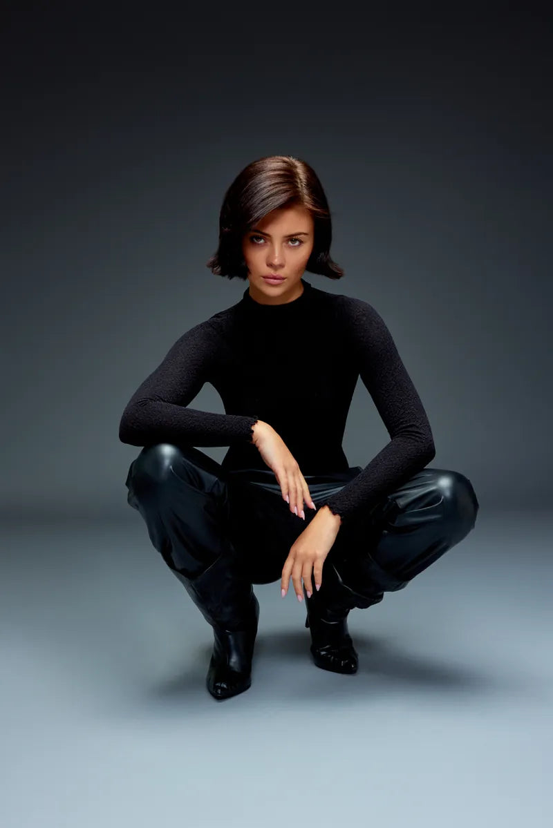 Model in black on a cool grey seamless