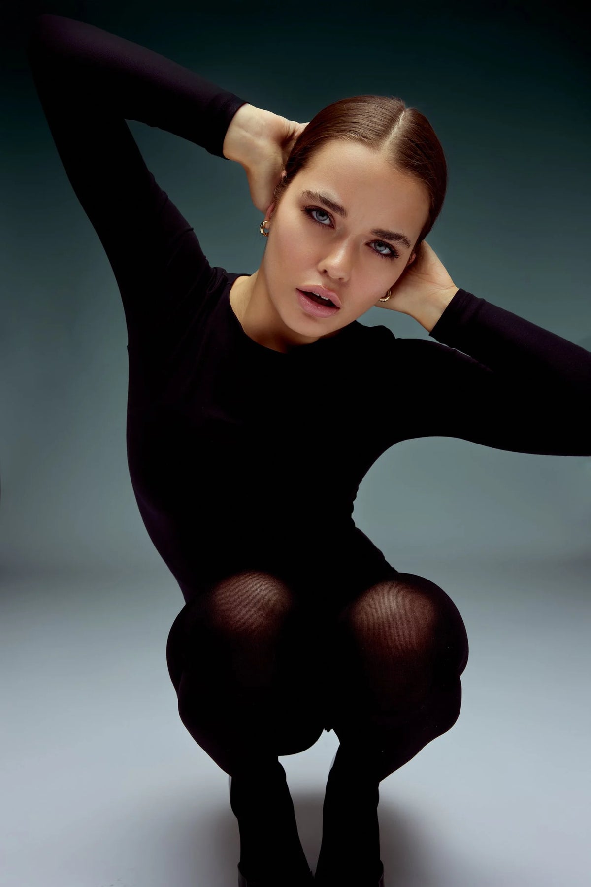 Black knit look, kneeling with arm overhead