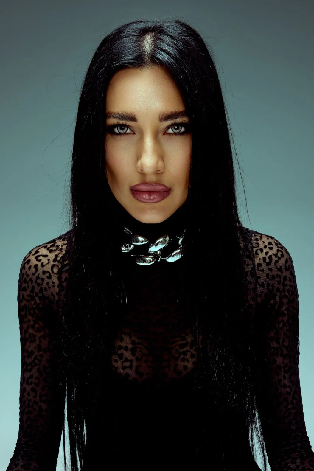 Woman with long black hair in black lace, direct gaze